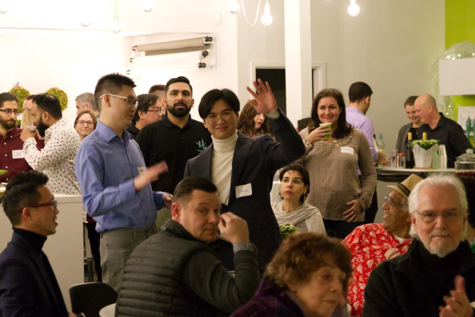 large group of people at a function with one man waving to the camera