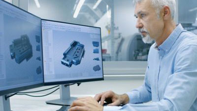 Man working at a computer with 3d parts