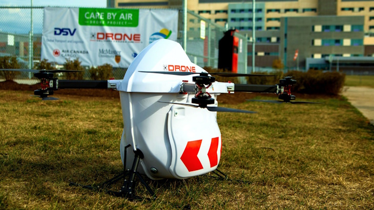 Drone Delivery Canada drone parked on grass in front of a building