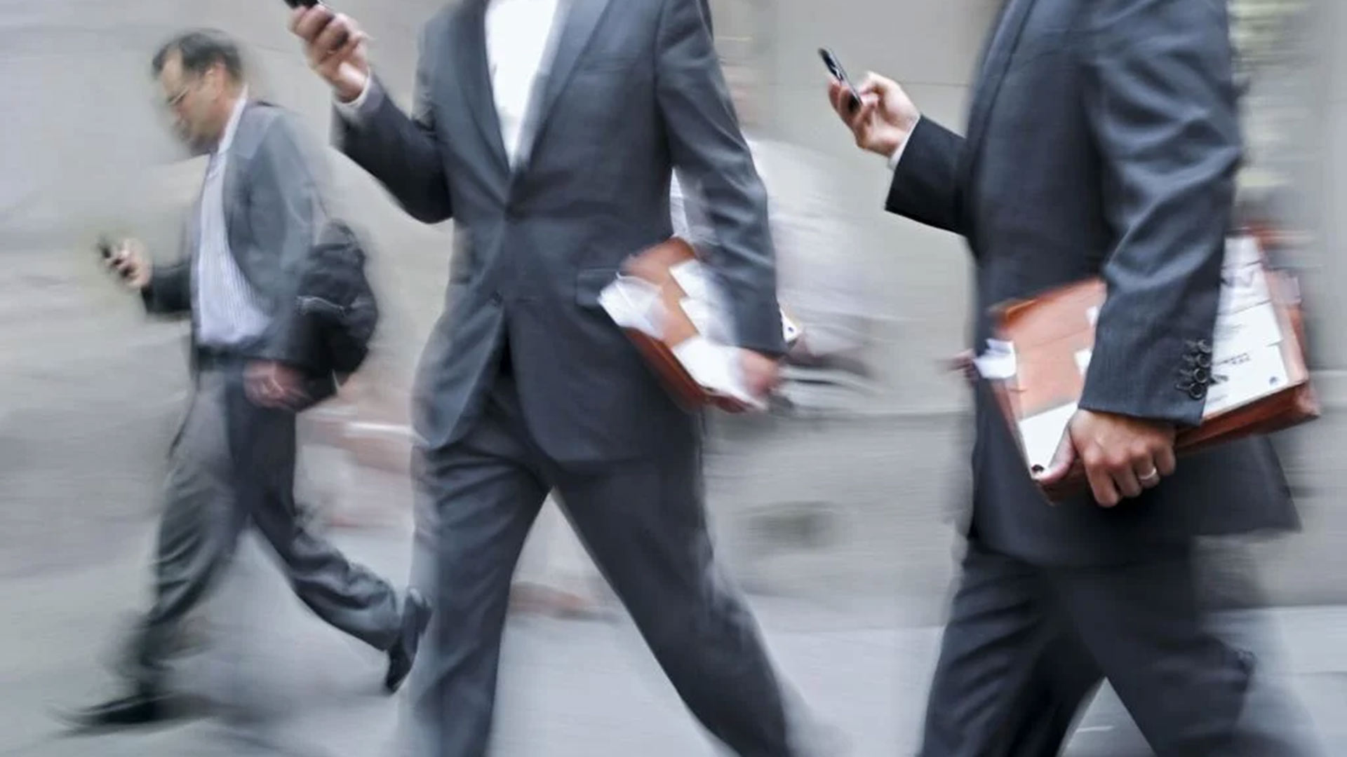 A man in a suit looking at a phone