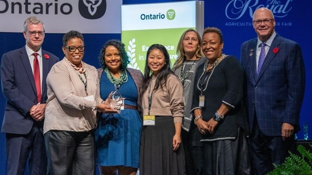 Award recipients holding award and smiling 